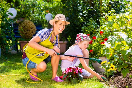 Mower cutting a neat lawn with surrounding flower beds in Brimsdown